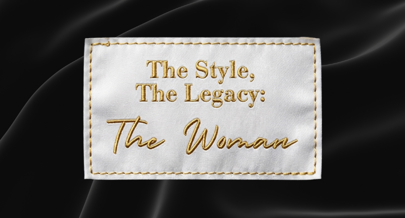 2026 Culture Days - Exhibit at Museum EventON (800 x 600 px) (1) White fabric label with gold embroidered stitching and text reading "The Style, The Legacy: The Woman," displayed against a black satin fabric background.